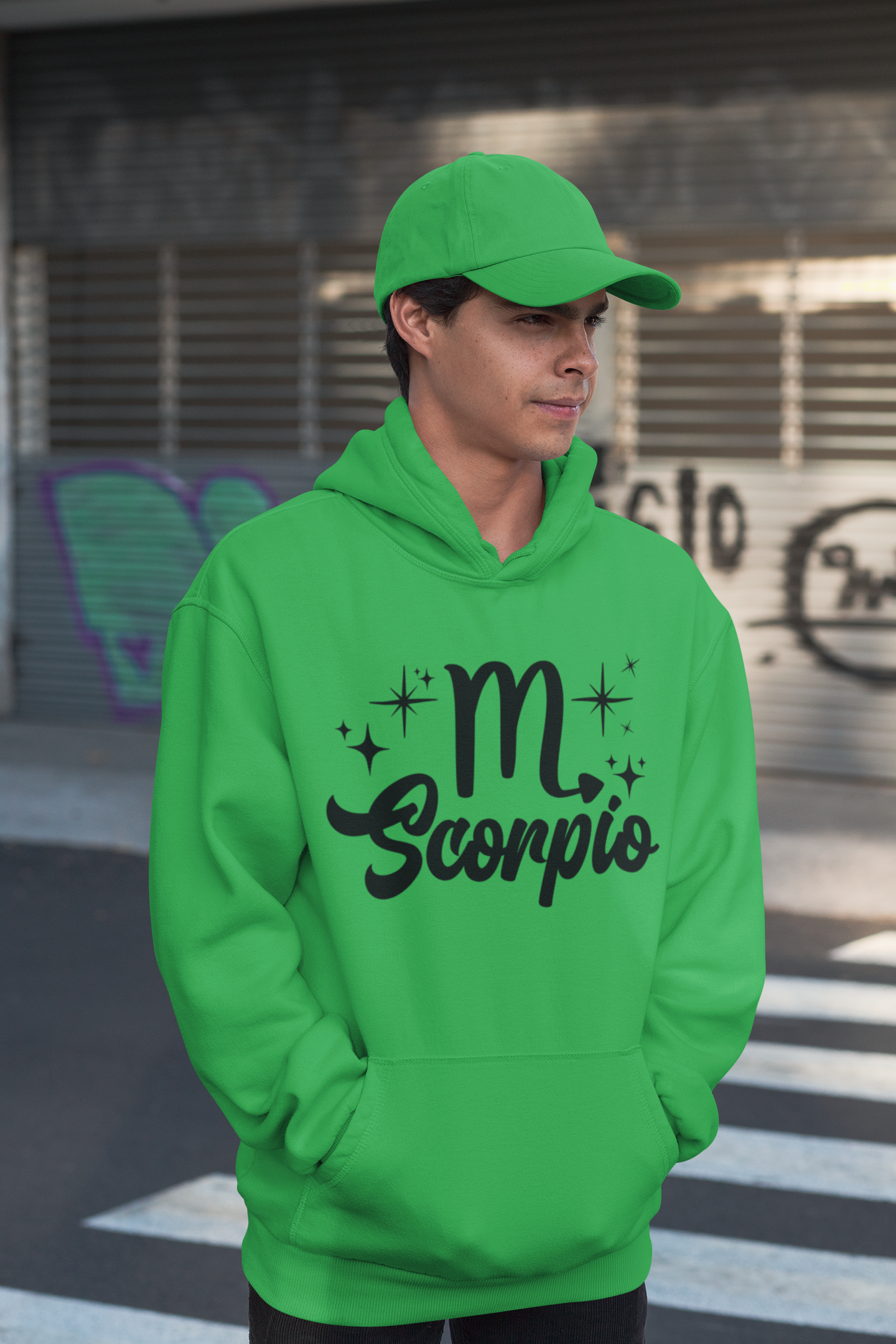 Person wearing a green hoodie with 'Scorpio' black text design, standing on a street.