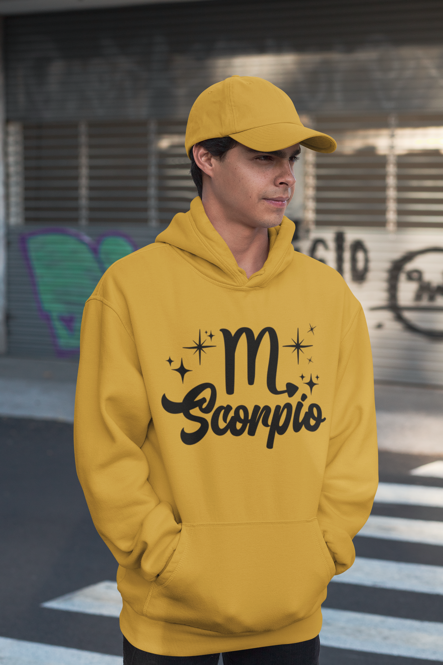 Person wearing a gold hoodie with 'Scorpio' black text design, standing on a street.