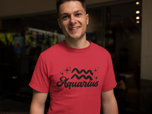 Person wearing a red t-shirt with 'Aquarius' black text design in a dark indoor setting