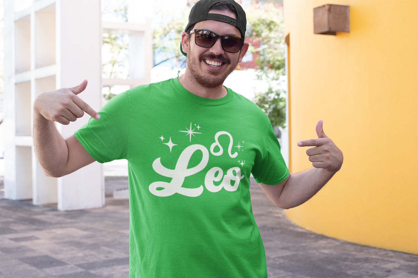 Man wearing a green t-shirt with 'Leo' white text design, giving thumbs up outdoors.