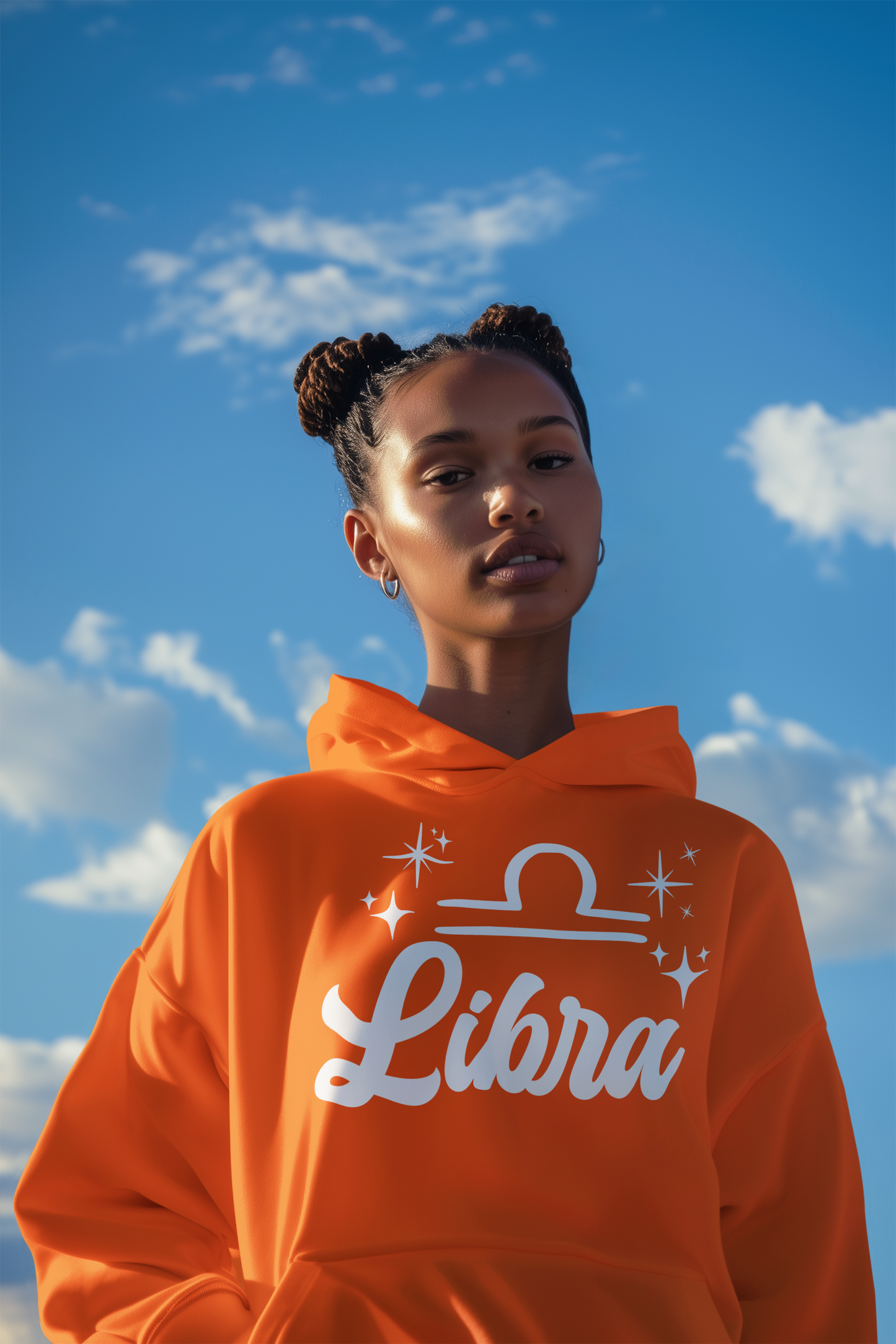 Person wearing a orange 'Libra' hoodie - white text design against a blue sky with clouds