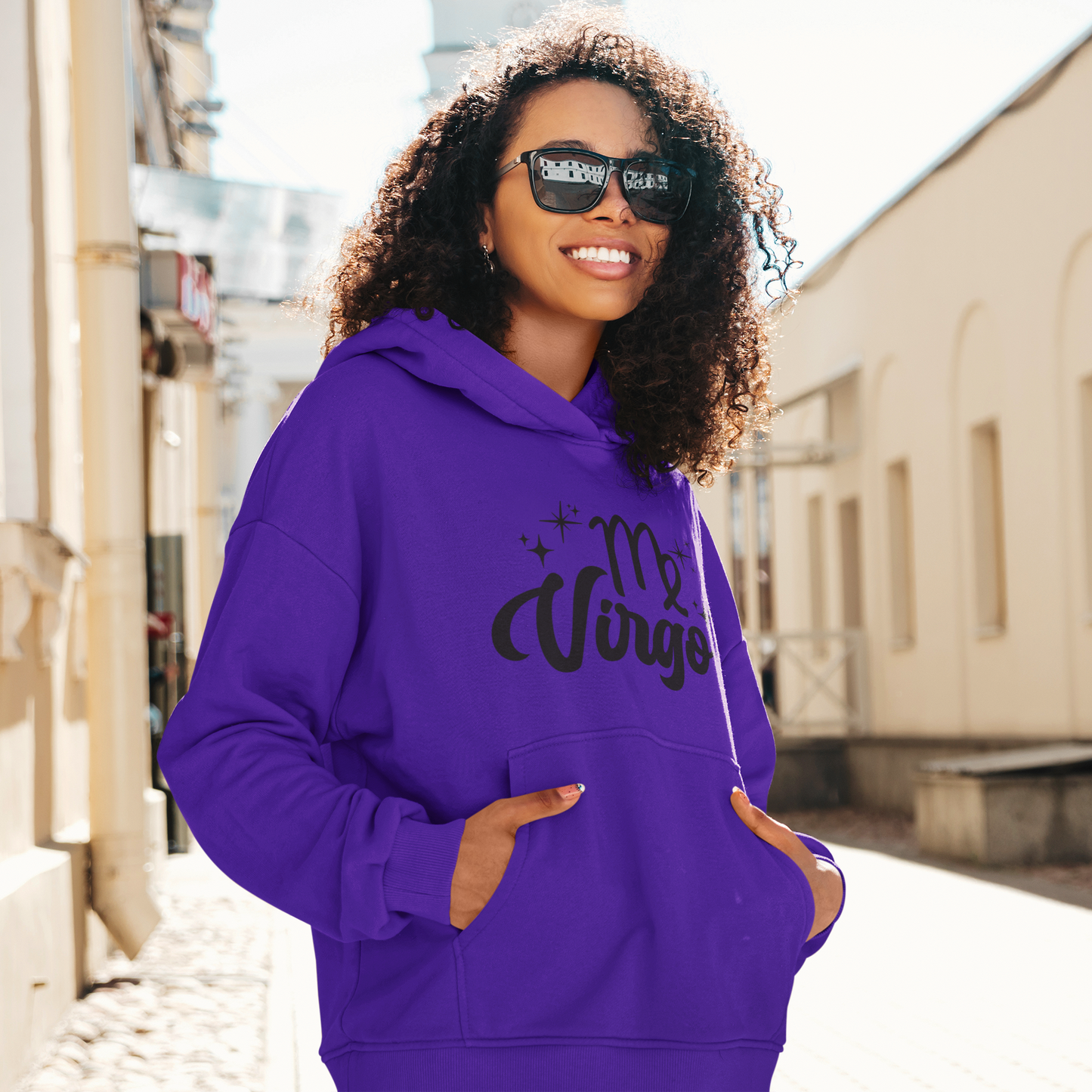 Woman with sunglasses, wearing a purple hoodie with "Virgo' black text design standing on the street.